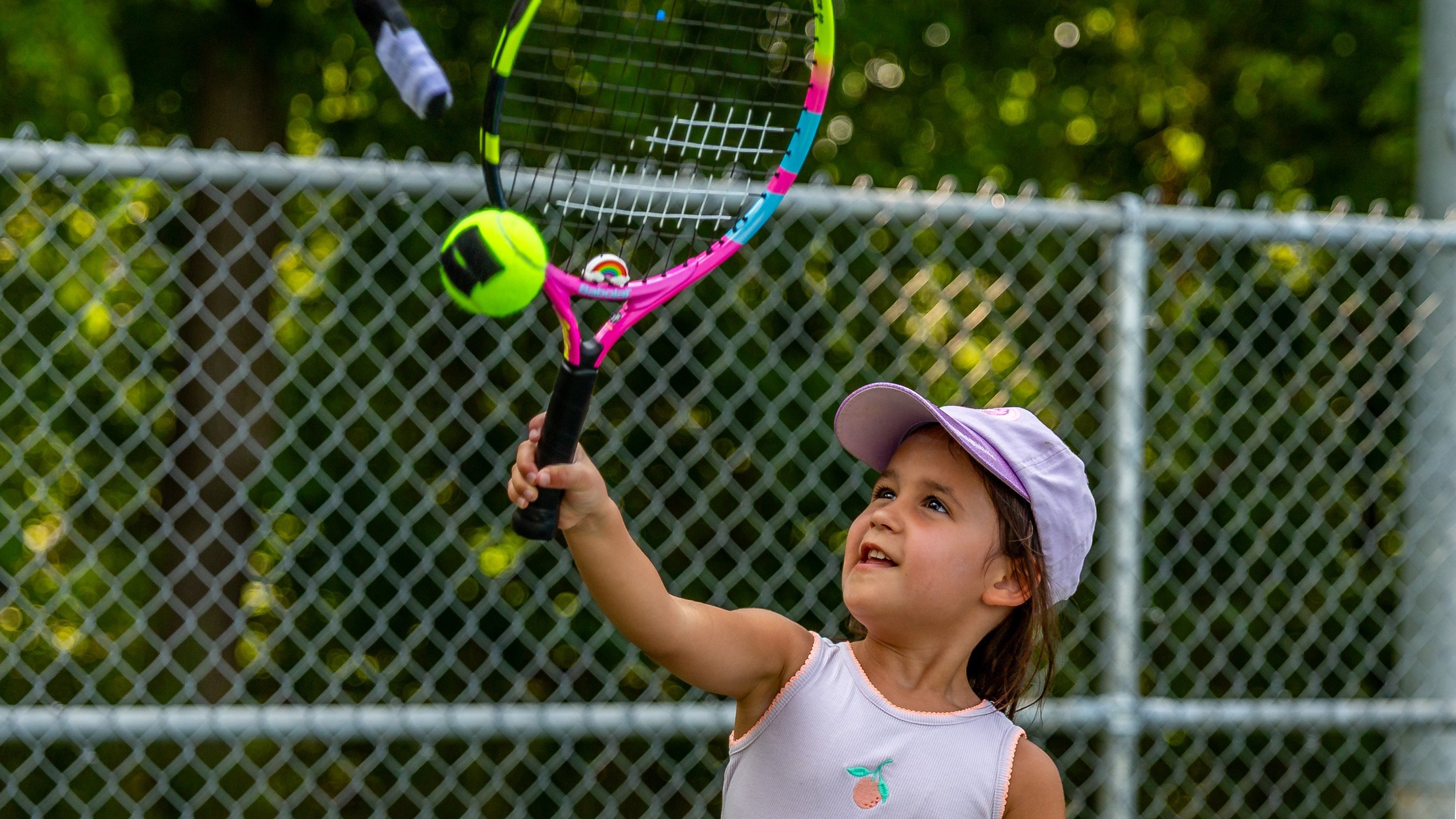 A little girl hits a tennis ball with her racket during a tennis class at Port Weller Community Centre.