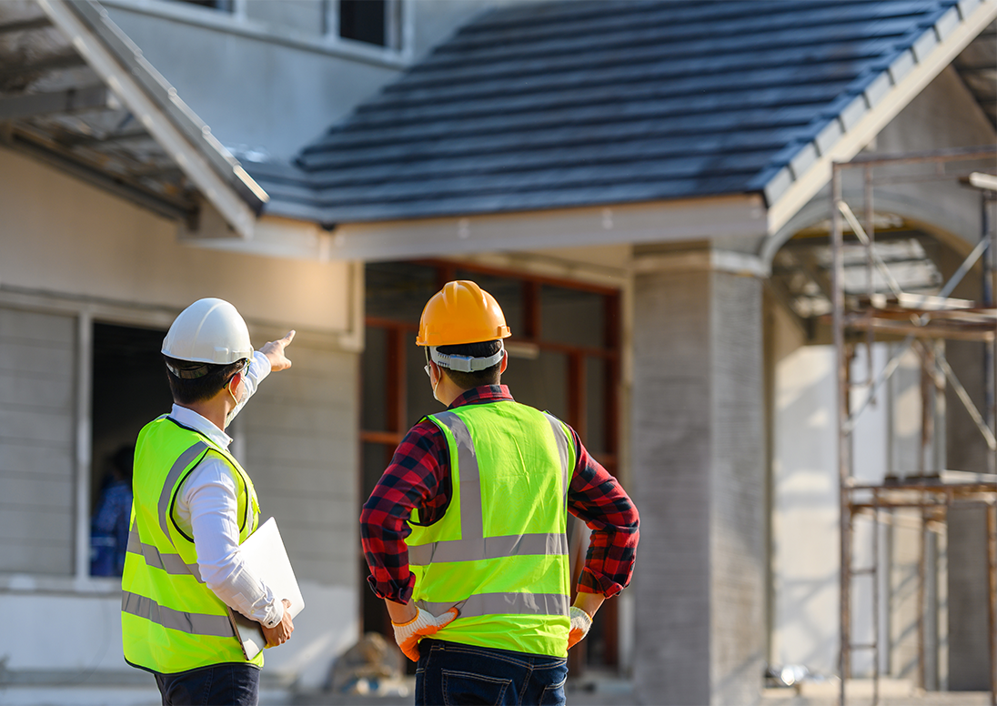 Construction workers pointing at a building under construction