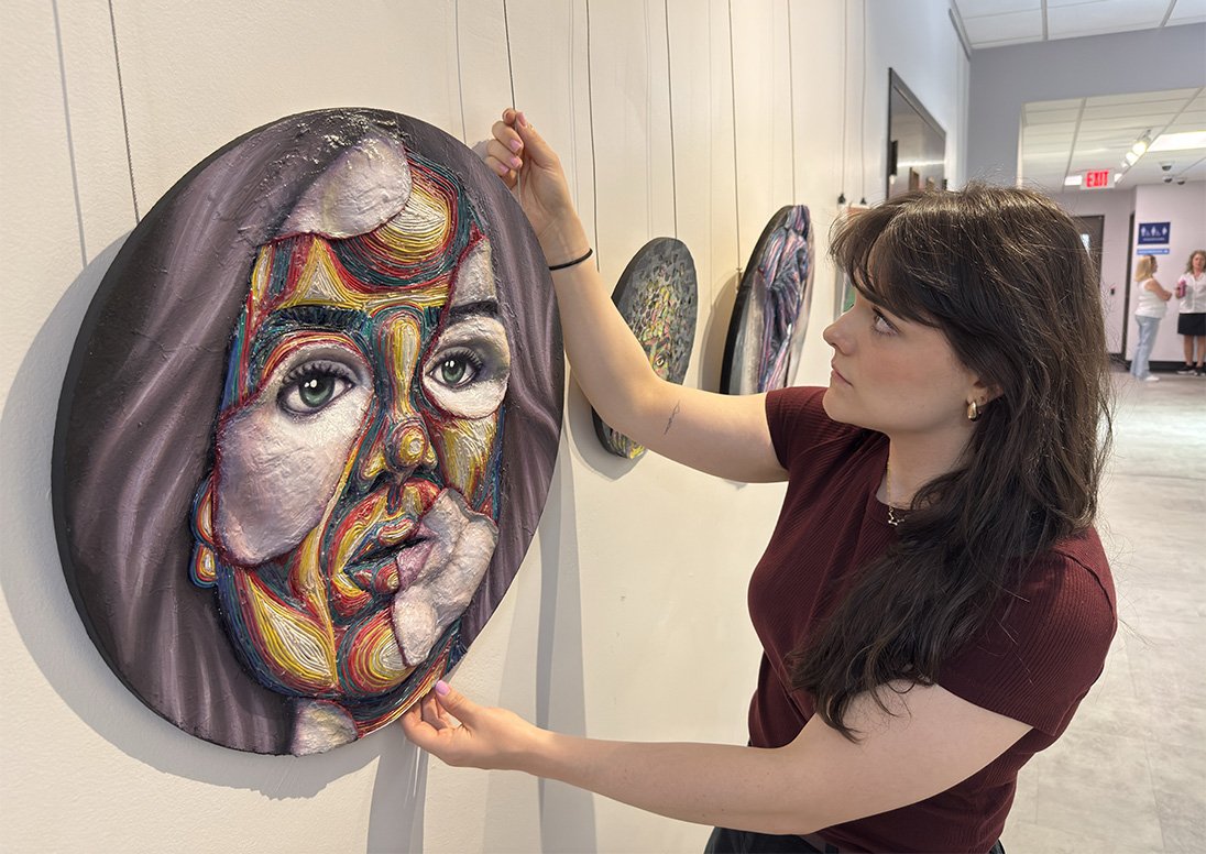 City Culture Coordinator Chelsea Ryan hangs a work of art in the Third-Floor Gallery at City Hall, part of the art exhibition, titled “Full Colour: A Celebration of 2SLGBTQIA+ Art and Expression,” on display during Pride Month through Aug. 14, 2026.