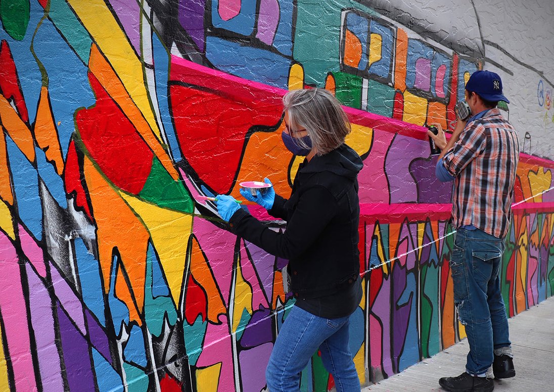 Individuals painting a mural