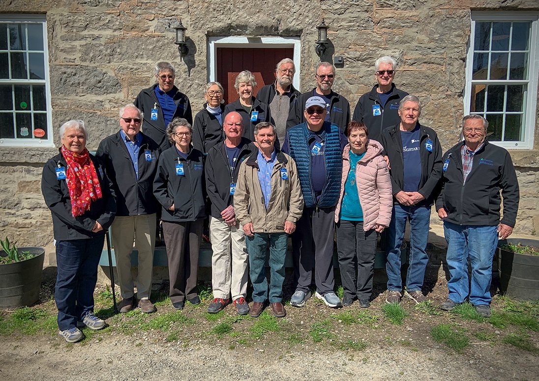 group of people standing in front of historic mill