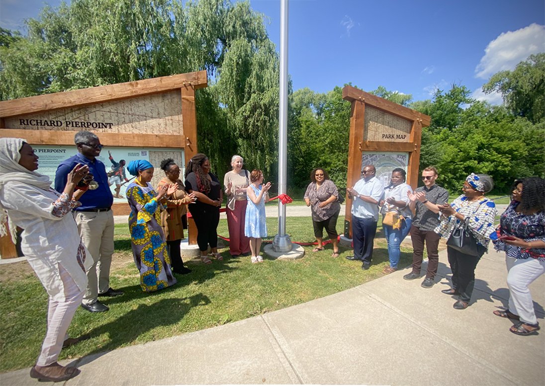 People applauding the cutting of a ribbon