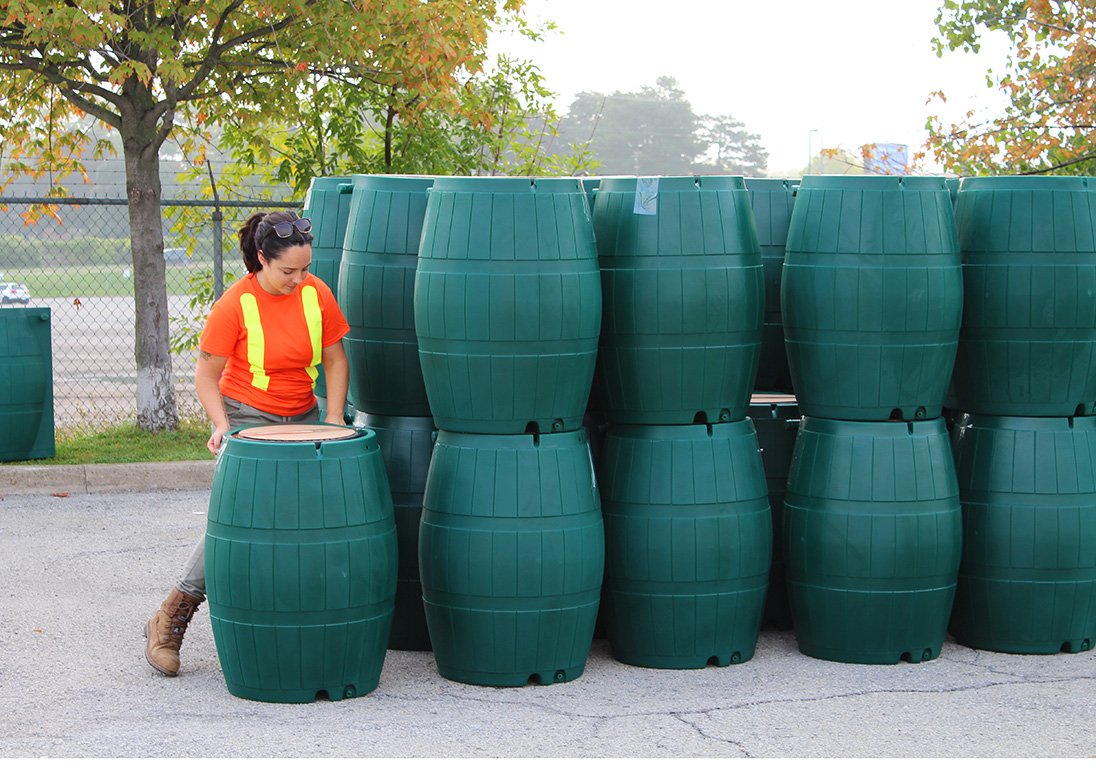 A City staff person readies the next rain barrel to load into a St. Catharines resident's car on pickup day.
