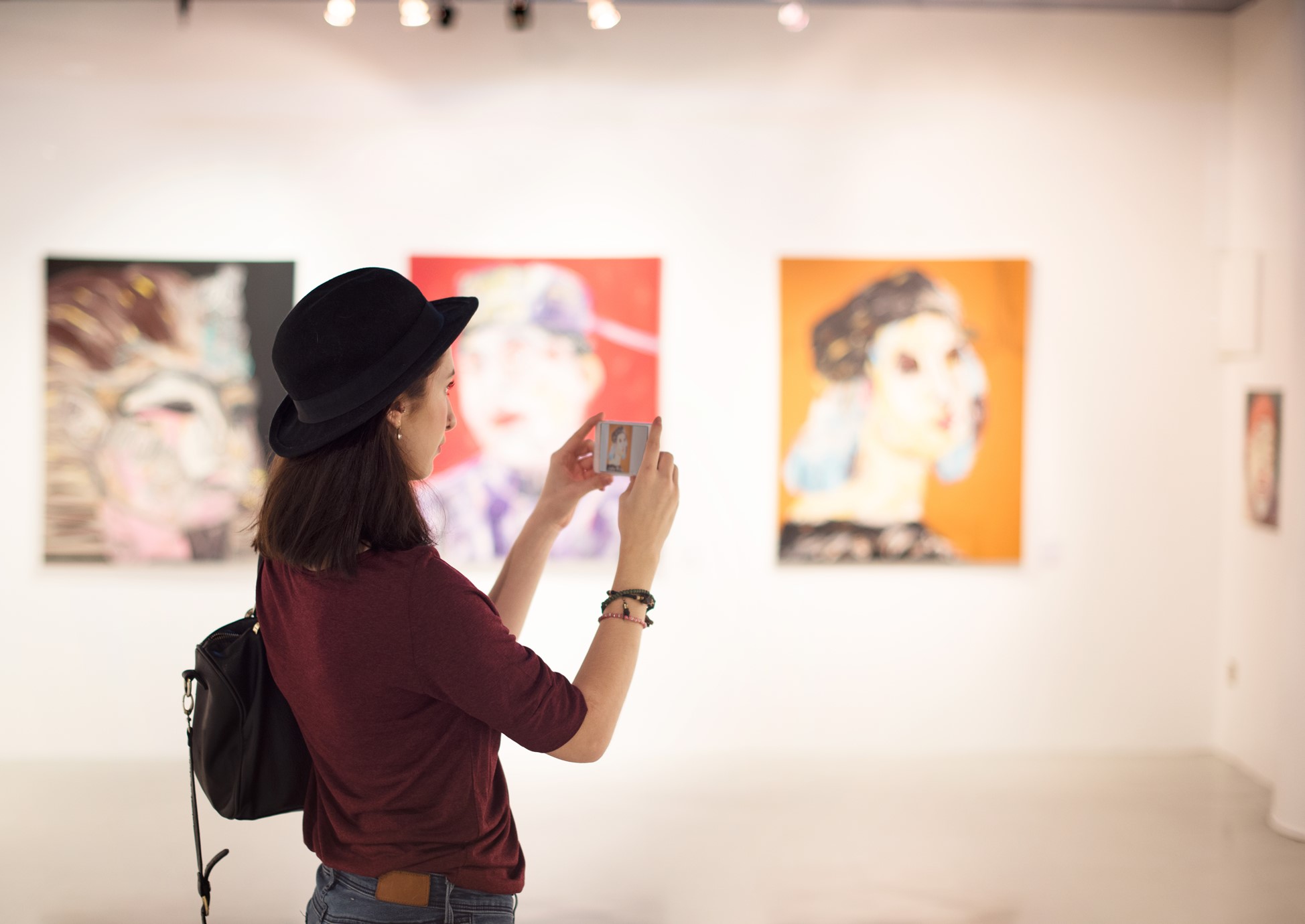 Woman taking photograph of artwork on a mobile phone
