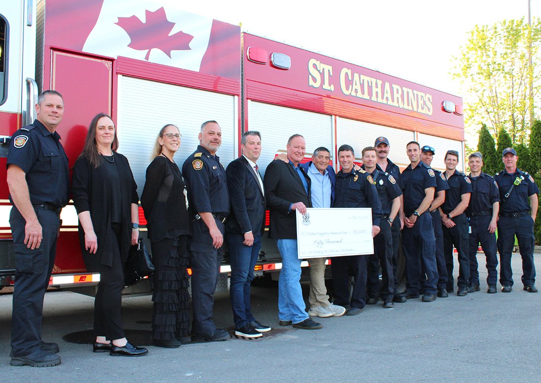 Fire Chief Dave Upper, Ryan Madill, president of St. Catharines Professional Firefighters Association Local 485, St. Catharines Firefighters and Fire Services staff and and Fallen Firefighters Memorial Task Force members with Barry Katzman after St. Catharines Club donated $50,000 to the St. Catharines Fallen Firefighters Memorial.