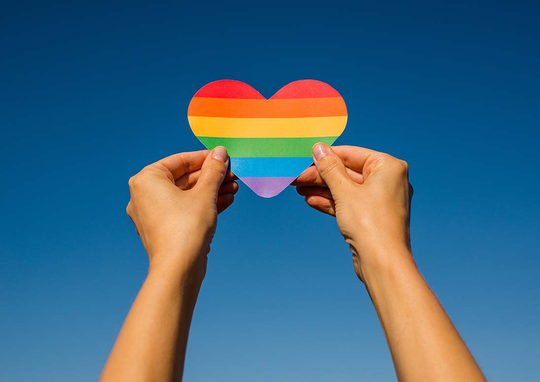 Woman holding a rainbow heart in her hands
