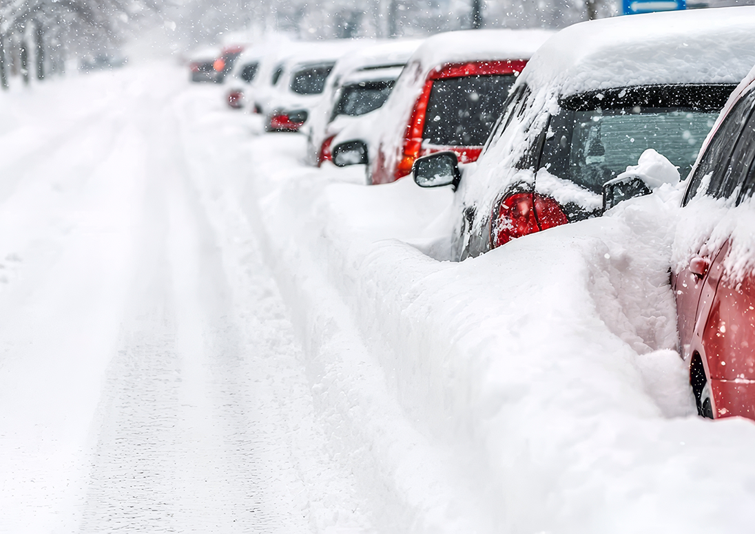 A lineup of cars buried in snow