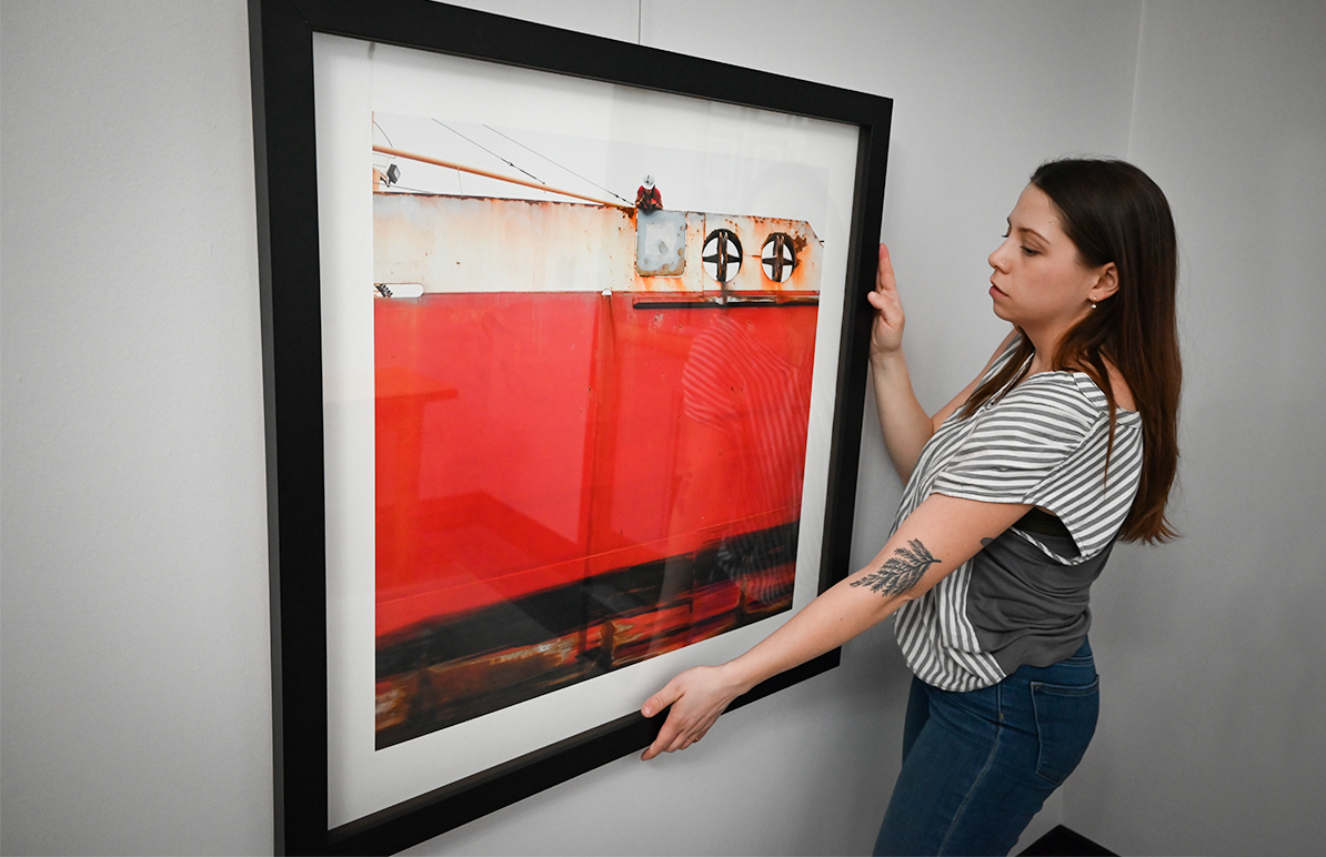 Waterscapes art being hung on wall