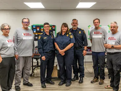 St. Catharines Fire Chief Dave Upper and deputy chiefs Andrea Dejong and Trevor Parker meet with members form Ontario Corps partner Team Rubicon.
